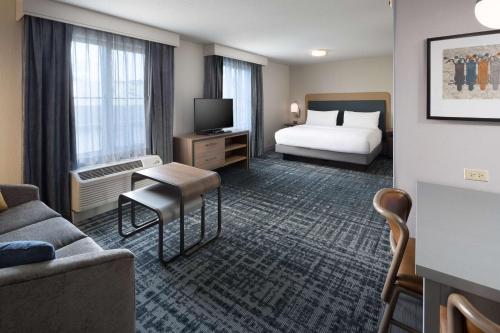 Habitación de hotel con cama y TV en Homewood Suites by Hilton Newburgh-Stewart Airport en New Windsor