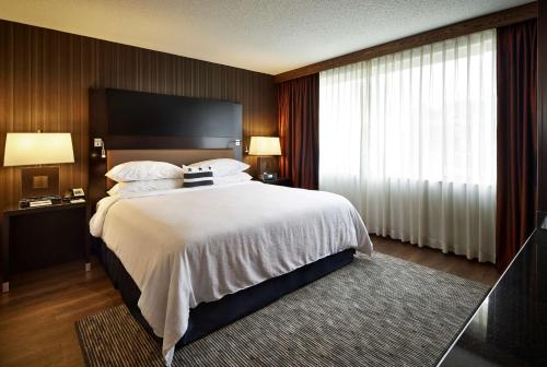 ein Hotelzimmer mit einem großen Bett und einem Fenster in der Unterkunft Embassy Suites by Hilton Washington DC Chevy Chase Pavilion in Washington