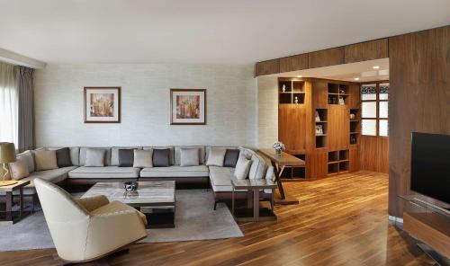 a living room with a couch and a tv at Transcorp Hilton Abuja in Abuja