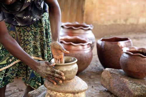 a woman making a vase on a pottery wheel at Transcorp Hilton Abuja in Abuja