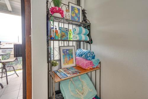 a room with a shelf with towels and pictures at Downtown Kailua-Kona Condo with Pool and Views in Kailua-Kona
