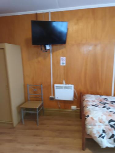 ein Schlafzimmer mit einem Bett und einem TV an der Wand in der Unterkunft Hotel CasaGrande in Valdivia