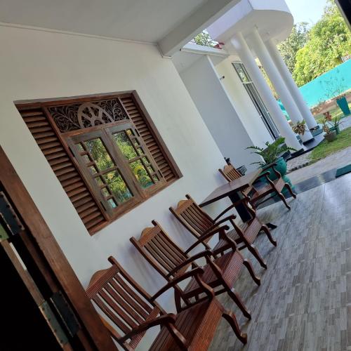 a room with a table and chairs and a window at White Win Villa in Elewala