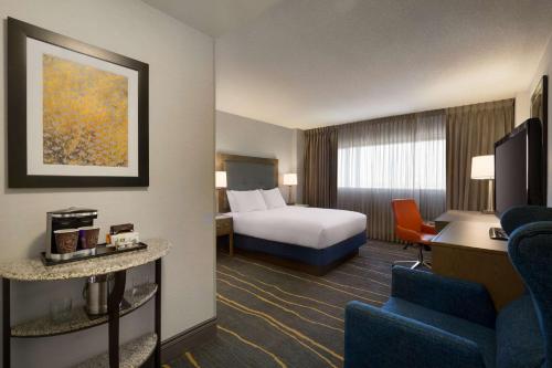 um quarto de hotel com uma cama e uma secretária com uma cadeira em DoubleTree by Hilton Hotel Albuquerque em Albuquerque