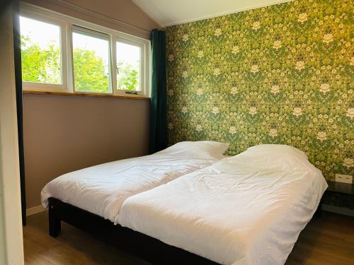 a bed in a bedroom with flowers on the wall at Gastenverblijf in rustige groene omgeving - Kievit Leuvenheim in Leuvenheim
