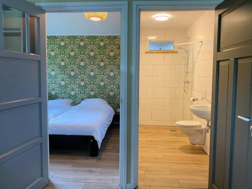 a bathroom with a bed and a sink and a toilet at Gastenverblijf in rustige groene omgeving - Kievit Leuvenheim in Leuvenheim