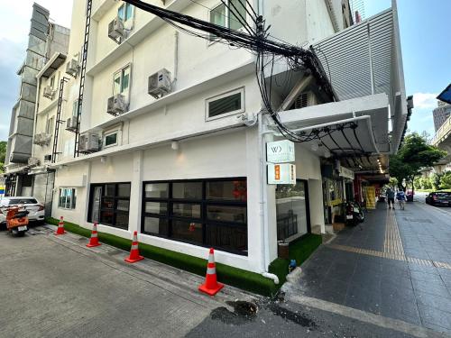a building with orange cones in front of a street at The White Den Sukhumvit 44 in Bangkok