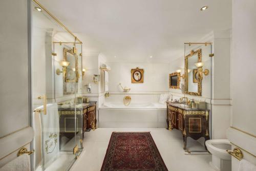 a white bathroom with a tub and a sink and a tub at Hilton Alexandria Corniche Hotel in Alexandria