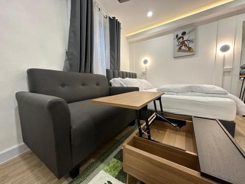 a living room with a couch and a bed at The White Den Sukhumvit 44 in Bangkok