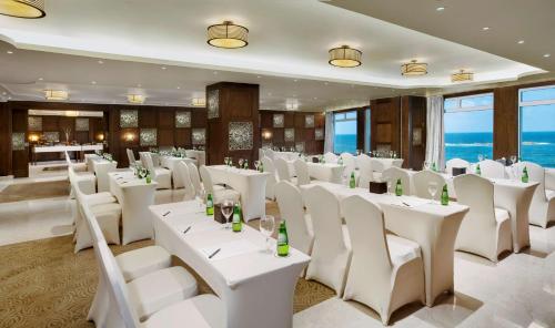 a banquet hall with white tables and chairs at Hilton Alexandria Corniche Hotel in Alexandria