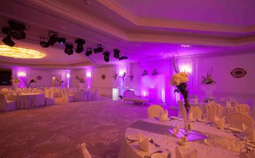 a banquet hall with white tables and purple lighting at Hilton Alexandria Corniche Hotel in Alexandria