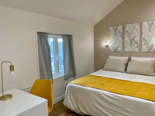 a bedroom with a bed and a desk and a window at Le Cocon - logement 4 personnes - Neuf - Wifi in Le Bourget