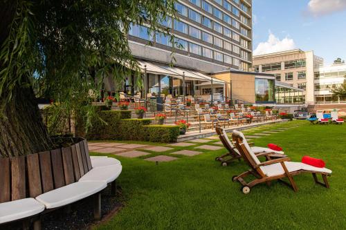 een gebouw met stoelen en tafels in het gras bij Hilton Amsterdam in Amsterdam