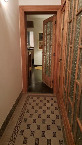 um corredor com portas de madeira e piso em azulejo em Henriëtta em Hoboken