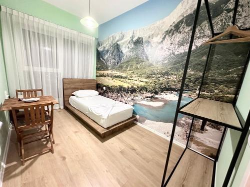 a bedroom with a mountain mural on the wall at 107 Dreams in Tirana