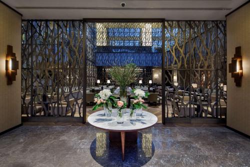 a dining room with a table with flowers on it at Ankara HiltonSA in Ankara