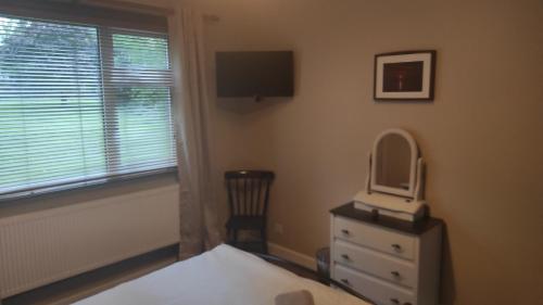 a bedroom with a bed and a mirror and a window at Retreat by the Feale in Listowel