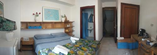 um pequeno quarto com uma cama e uma casa de banho em per noi 2 em Capo dʼOrlando