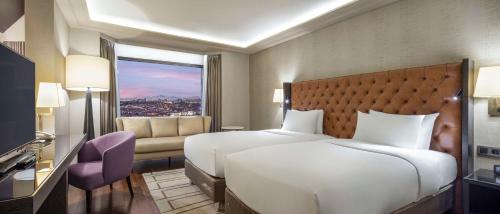 a hotel room with a bed and a window at Ankara HiltonSA in Ankara