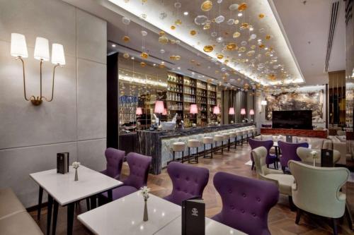 a restaurant with purple chairs and a bar at Ankara HiltonSA in Ankara