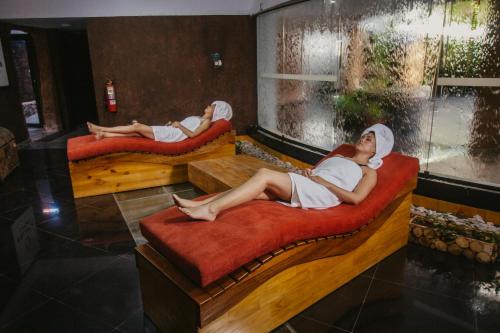two women laying on beds in a room at Hacienda del Valle Sagrado in Urubamba