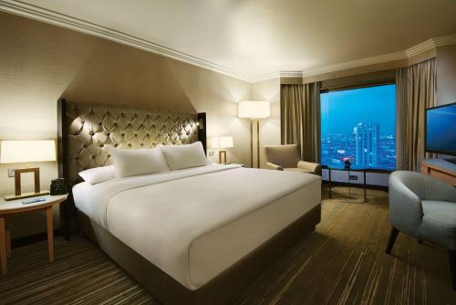 a hotel room with a large bed and a television at Ankara HiltonSA in Ankara