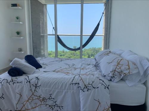 Amazing Penthouse. A minutos de la playa. في سانتا مارتا: سرير في غرفة مع نافذة كبيرة