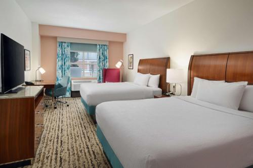 a hotel room with two beds and a flat screen tv at Hilton Garden Inn Atlanta Midtown in Atlanta