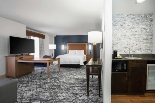 オースティンにあるHampton Inn & Suites Austin-Downtown/Convention Centerのベッドとデスクが備わるホテルルームです。