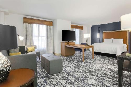 a hotel room with a bed and a living room at Hampton Inn & Suites Austin - Downtown in Austin