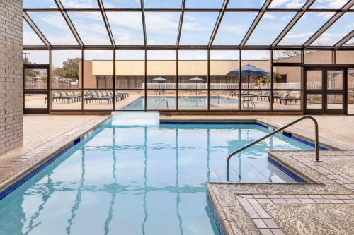 a swimming pool with blue water in a building at Hilton Arlington in Arlington