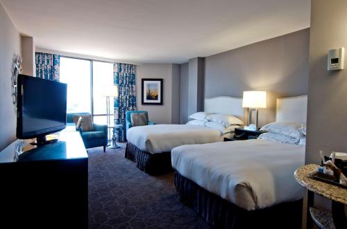 a hotel room with two beds and a flat screen tv at Hilton Arlington in Arlington