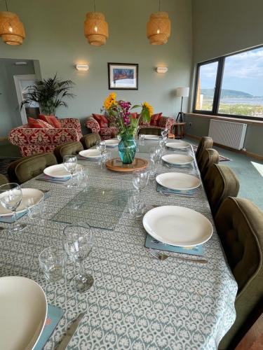 a long table with plates and wine glasses on it at Spacious Sea View Home 5 miles from Inverness in North Kessock