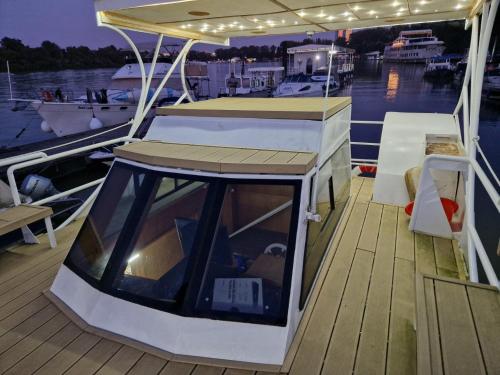 a boat with a canopy on a dock at Free Room Boat Apartment in Belgrade