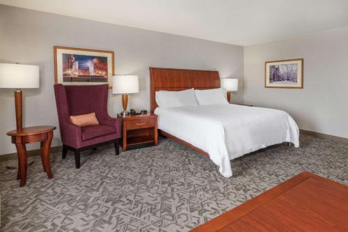 um quarto de hotel com uma cama e uma cadeira em Hilton Garden Inn Blacksburg University em Blacksburg