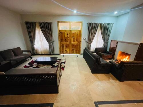 sala de estar con 2 sofás y chimenea en Two-Bedrooms Suite At Country Club Balakot, en Bālākot