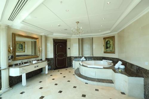 uma grande casa de banho com banheira e lavatório em Hilton Beirut Habtoor Grand Hotel em Beirute