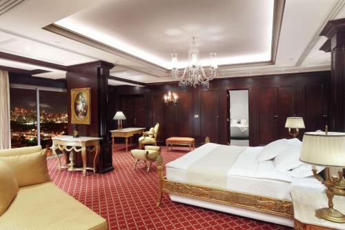 una camera con un grande letto e un lampadario a braccio di Hilton Beirut Metropolitan Palace Hotel a Beirut