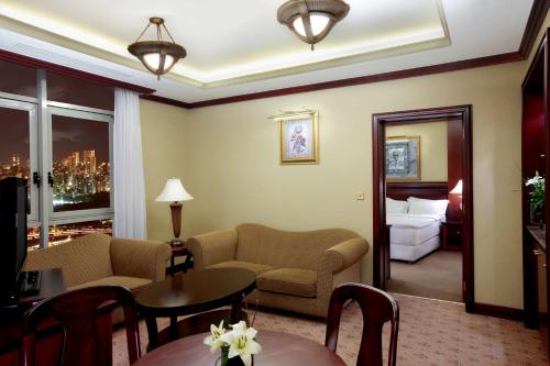 a living room with a couch and a bed at Habtoor Metropolitan Palace Hotel in Beirut
