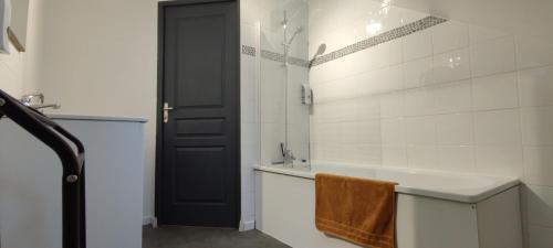 a bathroom with a black door and a bath tub at N°6 Annœullin - Appt 2 Chambres in Annoeullin