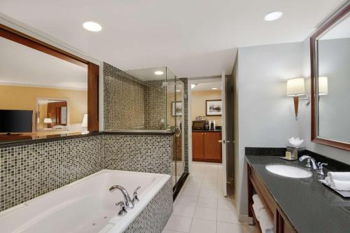 a bathroom with a tub and a sink at DoubleTree by Hilton Stamford in Stamford