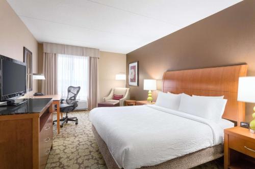 a hotel room with a bed and a television at Hilton Garden Inn Tuscaloosa in Tuscaloosa