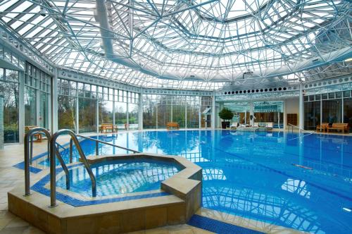 une grande piscine intérieure avec un plafond en verre dans l'établissement Hilton Birmingham Metropole Hotel, à Bickenhill