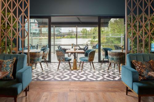 a restaurant with tables and chairs and a view of the water at Hilton Birmingham Metropole Hotel in Bickenhill