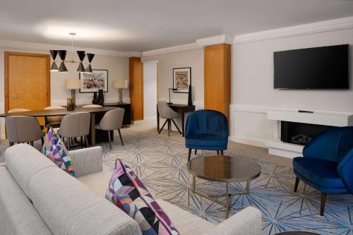 a living room with a couch and a table and a television at Hilton Birmingham Metropole Hotel in Bickenhill