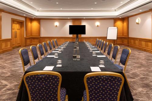 a conference room with a long table and chairs at Hilton Birmingham Metropole Hotel in Bickenhill