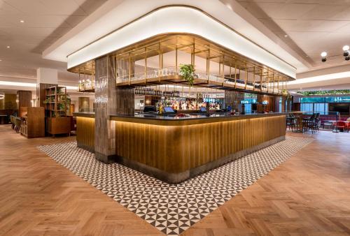 a lobby with a bar in a building at Hilton Birmingham Metropole Hotel in Bickenhill
