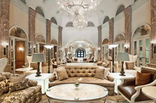 duży salon z kanapą i żyrandolem w obiekcie Hilton Mumbai International Airport Hotel w Bombaju