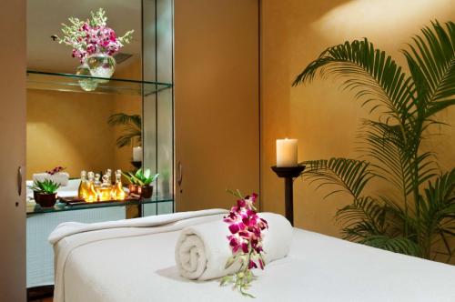 a hotel room with a bed with a candle and flowers at Hilton Mumbai International Airport Hotel in Mumbai