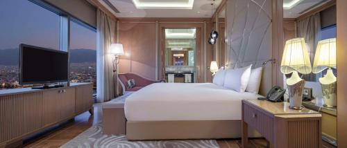a bedroom with a large bed and a television at Hilton Bursa Convention Center & Spa in Bursa